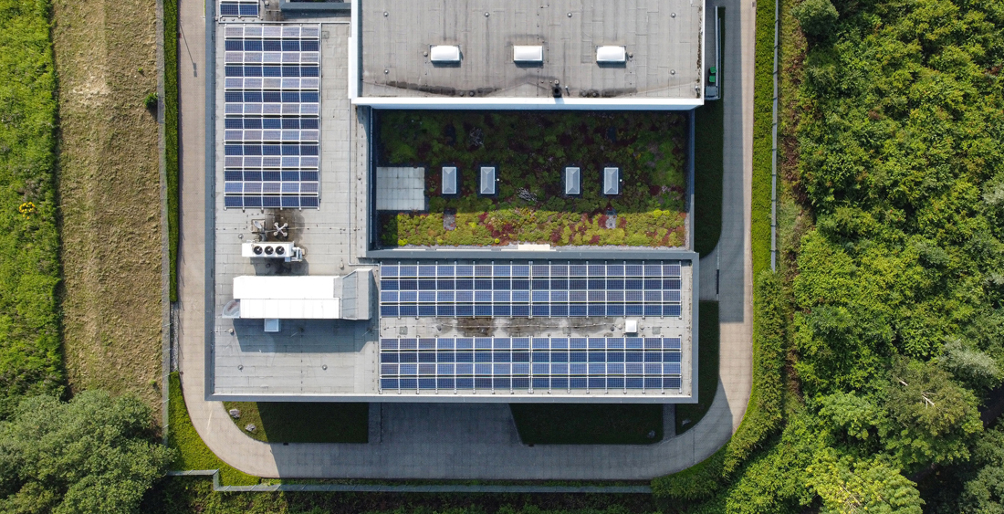 Gebäudedach mit Solarpanels und Grünflächen