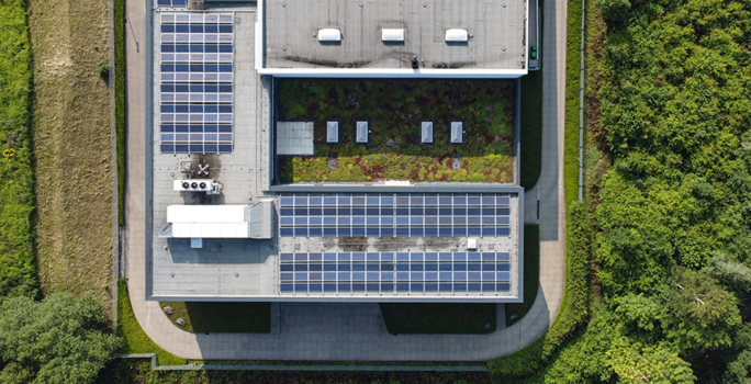 Das Dach des Firmengebäudes mit Solarpanels und grünen Flächen